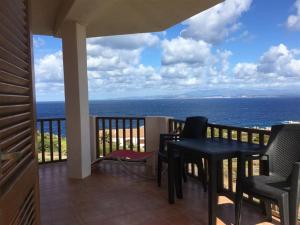 einen Balkon mit einem Tisch, Stühlen und Meerblick in der Unterkunft Residenza Lucia in Santa Teresa Gallura