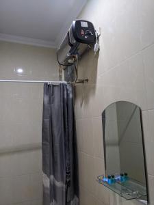 a bathroom with a shower curtain and a mirror at Casa Familia Syariah in Sleman