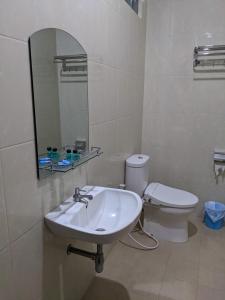 a white bathroom with a sink and a toilet at Casa Familia Syariah in Sleman