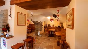 un restaurant avec une cheminée en pierre, des tables et des chaises dans l'établissement Le Mie Radici, à Scopello