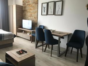 uma sala de estar com uma mesa de jantar e cadeiras em Milmari apartman SAN-28 em Kopaonik