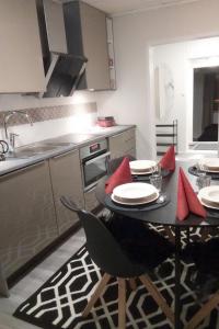 una cocina con mesa y sillas con almohadas rojas en Kuukkeli Ivalo Arctic House, en Ivalo