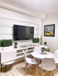 un soggiorno con tavolo, sedie e TV di 2 Bedroom Ocean Drive Newly Renovated a Miami Beach Altre 24 foto