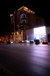 un edificio con coches estacionados en una calle por la noche en فندق بــــاســــيل en Hafr Al Batin
