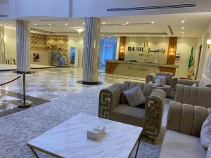 un hall d'un hôtel avec des canapés et un comptoir dans l'établissement فندق بــــاســــيل, à Hafr Al Baten