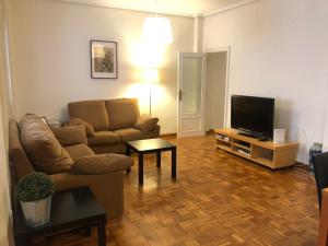 a living room with a couch and a flat screen tv at KM0 CENTRO CIUDAD in Valencia