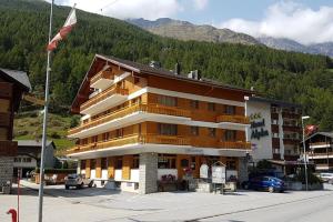 a large building with a flag in front of it at Hotel Krone - only Bed & Breakfast in Saas-Grund