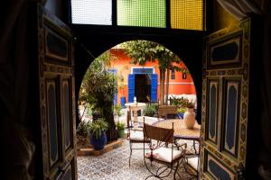 an archway with chairs and tables in a courtyard at Riad 7 Rijal Marrakech in Marrakesh