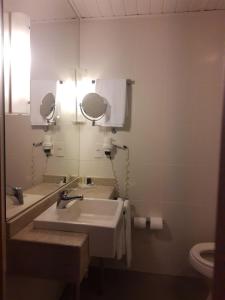 a bathroom with two sinks and a mirror at Novotel Porto Alegre Airport in Porto Alegre