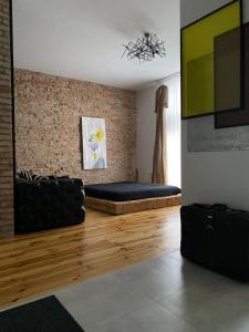 a living room with a couch and a brick wall at Smolynja style in Ternopilʼ