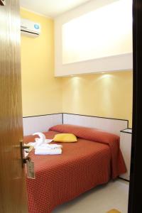 sypialnia z czerwonym łóżkiem i ręcznikami w obiekcie Hotel Lugano w Mediolanie