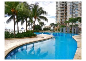 a swimming pool with palm trees and a building at Subang City Residence, 8-9 pax with Balcony, Walking Distance to Summit, 5min to Sunway in Subang Jaya