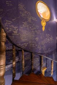 a wall covered in writing on a wall with a mirror at The Clock Hostel & Suites in Cartagena de Indias