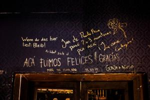 a wall with writing on it with a sign on it at The Clock Hostel & Suites in Cartagena de Indias