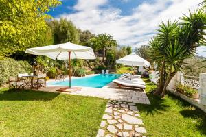 una piscina con ombrellone, sedie e tavolo di Villa Sole di Capri - Vista Mare a Massa Lubrense