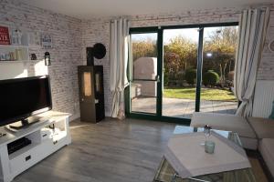 a living room with a couch and a tv at Ferienhaus Blomengoorn in Boltenhagen