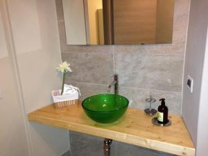 lavabo en el baño con un tazón verde en una encimera de madera en B&B Videtti, en Villongo SantʼAlessandro