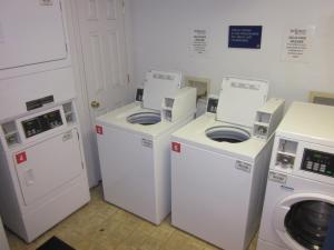 une buanderie avec 3 lave-linge et un lave-linge/sèche-linge dans l'établissement InTown Suites Extended Stay Greenville NC, à Greenville