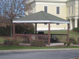a wooden gazebo in front of a house at InTown Suites Extended Stay Greenville NC in Greenville