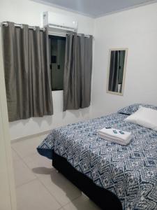 a bedroom with a bed with a towel on it at Kitnet 2 mobiliada centro de Torres RS, a 600m Da Praia Grande in Torres