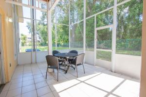 a room with a table, chairs, and a window at Berkley Lake Townhomes in Kissimmee