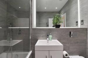 a bathroom with a sink and a shower and a toilet at Luxury 1 Bed Flat in St Albans, Modern, WiFi, Six Minutes from Train Station in Saint Albans +18 photos