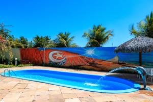 a swimming pool with a water fountain in front of a wall at Pousada Iguana in Canoa Quebrada