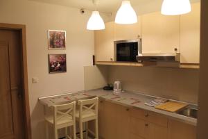 a kitchen with a counter and two stools in it at Hostel Kubik in Kraków