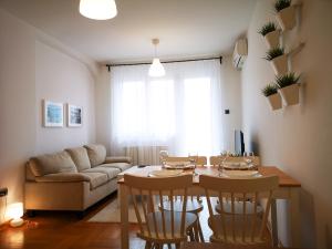 uma sala de estar com uma mesa e cadeiras e um sofá em FilinHome Dusana 3-bedroom Suite em Novi Sad