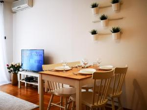 uma mesa de jantar com cadeiras e uma televisão em FilinHome Dusana 3-bedroom Suite em Novi Sad