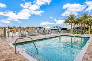 uma piscina com palmeiras num resort em Dolphin's Cove - Clearwater Beach, FL em Clearwater Beach