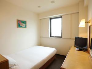 Habitación de hotel con cama y TV en Smile Hotel Towada, en Towada