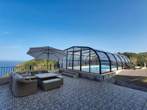 une terrasse avec une piscine et une serre dans l'établissement Casa Leão de Ouro by LovelyStay, à São Jorge
