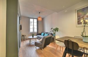 een woonkamer met een tafel en een bank bij Superbe T2 de 45m² en hyper centre in La Rochelle