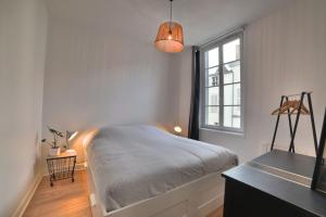 a bedroom with a bed and a window at Superbe T2 de 45m² en hyper centre in La Rochelle