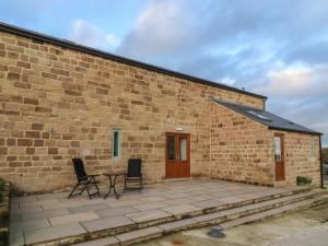 a brick building with a table and chairs on a patio at Ploughman's Rigg in Harrogate