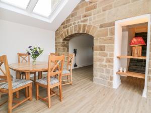 a dining room with a table and chairs and a brick wall at Shepherd's Crook in Harrogate