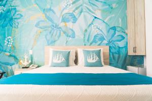 1 dormitorio con 1 cama con papel pintado de flores azul en Sea Colors Hotel en San Andrés