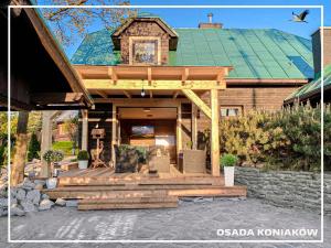 Osada Koniaków 3 في كونيكاو: منزل مع شرفة خشبية مع سقف