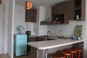 a kitchen with a blue refrigerator and wooden cabinets at Aparthotel Serena in La Serena