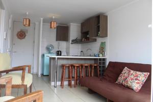 a living room with a couch and a kitchen at Aparthotel Serena in La Serena +18 photos