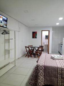 cocina y comedor con mesa y sillas en Kitnet 1 mobiliada no centro de Torres a 600m da Praia Grande, en Torres