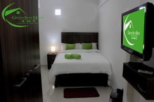 a hotel room with a bed with a tv on the wall at Green Stay house in Maputo