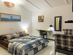 a bedroom with a bed and a desk in it at Hotel Blawa in Abidjan