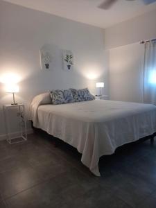 a bedroom with a large bed with two lamps at Complejo Pirovano in Lincoln