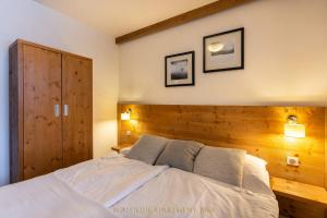 a bedroom with a large bed with a wooden headboard at Boutique Apartment in Kukucka Residences in Tatranská Lomnica