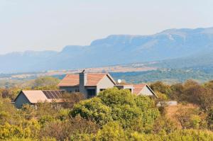 a house on a hill with mountains in the background at 774Ways Holiday Home in Hartbeespoort
