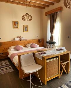 a bedroom with a large bed with a desk and a table at Zagreb Camp Bungalows in Rakitje