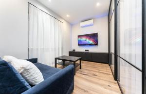 sala de estar con sofá azul y TV en Modern loft style apartment en Kiev