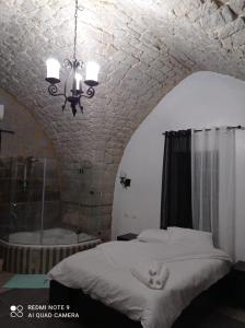 een slaapkamer met een bed, een bad en een kroonluchter bij Mandala in Mount מנדלה בחרמון סוויטה in Majdal Shams
